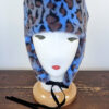 Cappello stile aviatore, con paraorecchie, in pelliccia sintetica leoparda. Mimi Condal.
