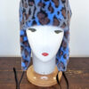 Cappello stile aviatore, con paraorecchie, in pelliccia sintetica leoparda. Mimi Condal.