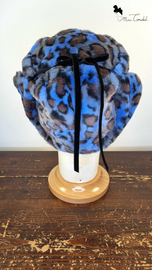 Cappello stile aviatore, con paraorecchie, in pelliccia sintetica leoparda. Mimi Condal.