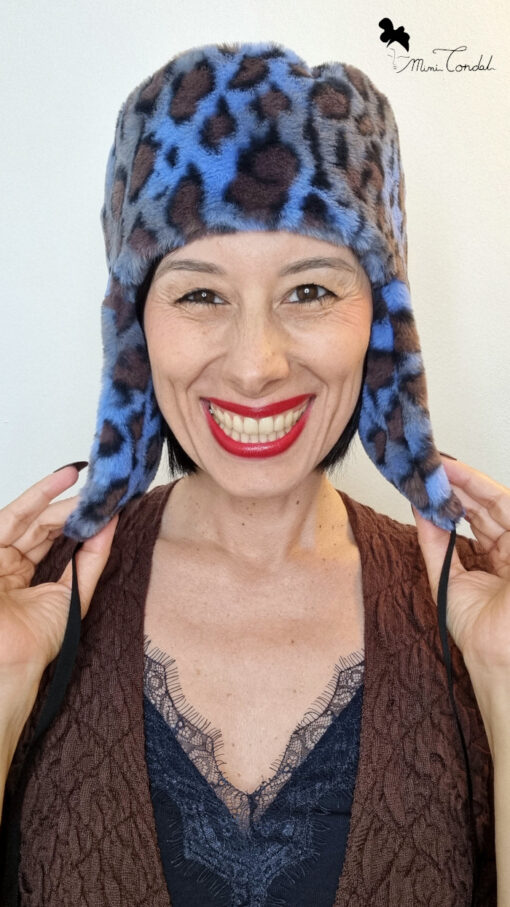 Mimi Condal mostra suo modello di cappello stile aviatore, con paraorecchie, in pelliccia sintetica leoparda,