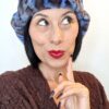 Mimi Condal mostra come indossare cappello stile aviatore, in pelliccia sintetica leoparda, con paraorecchie legate sopra ila testa.