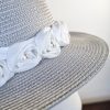 Elegante cappello estivo grigio abbellito con rose bianche in tessuto e perline, Mimi Condal