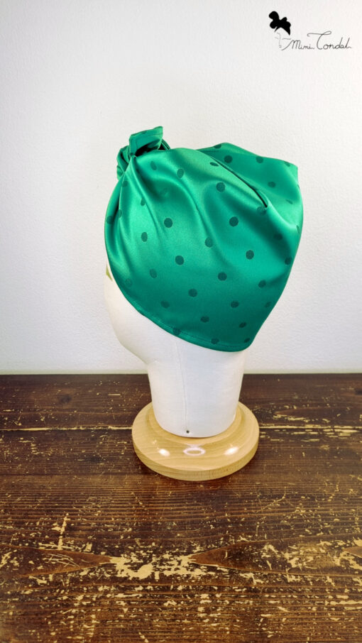 Turbante preformato ispirato alle iconiche bandane vintage. Elegante tessuto jaquard verde bottiglia a pois. Si annoda frontalmente. Mimi Condal.
