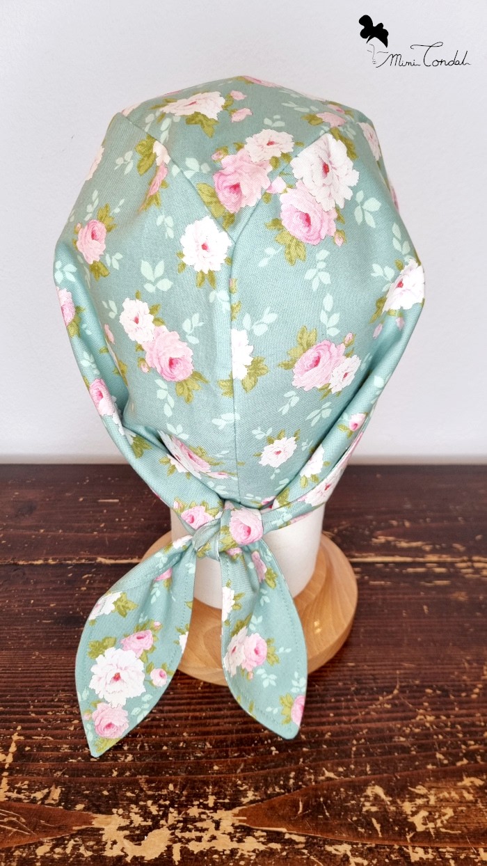Turbante bandana verde con fiori, dettaglio posteriore. Turbante preformato in cotone che si chiude come una bandana. Stampa fiori. Mimi Condal