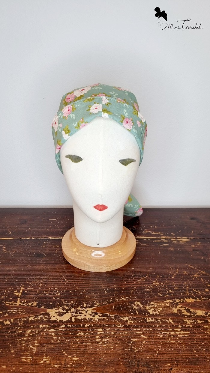 Turbante bandana verde con fiori, fronte. Turbante preformato in cotone che si chiude come una bandana. Stampa fiori. Mimi Condal