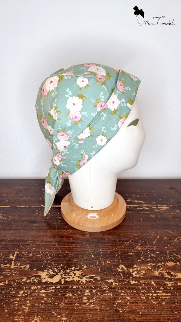 Turbante bandana verde con fiori, lato. Turbante preformato in cotone che si chiude come una bandana. Stampa fiori. Mimi Condal