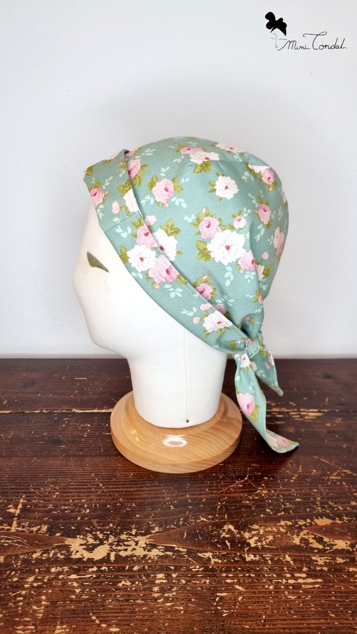 Turbante bandana verde con fiori, lato. Turbante preformato in cotone che si chiude come una bandana. Stampa fiori. Mimi Condal